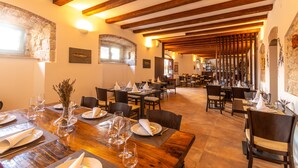 A restaurant with wooden beams, stone walls, and tables set for dining. - Heritage Villa Apolon (Stari Grad)