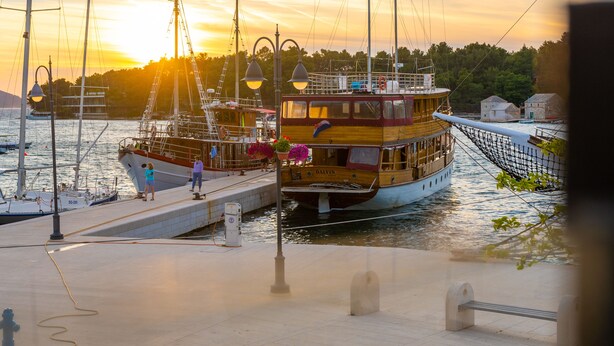 A docked boat with a cabin and a smaller boat beside it. - Heritage Villa Apolon (Stari Grad)