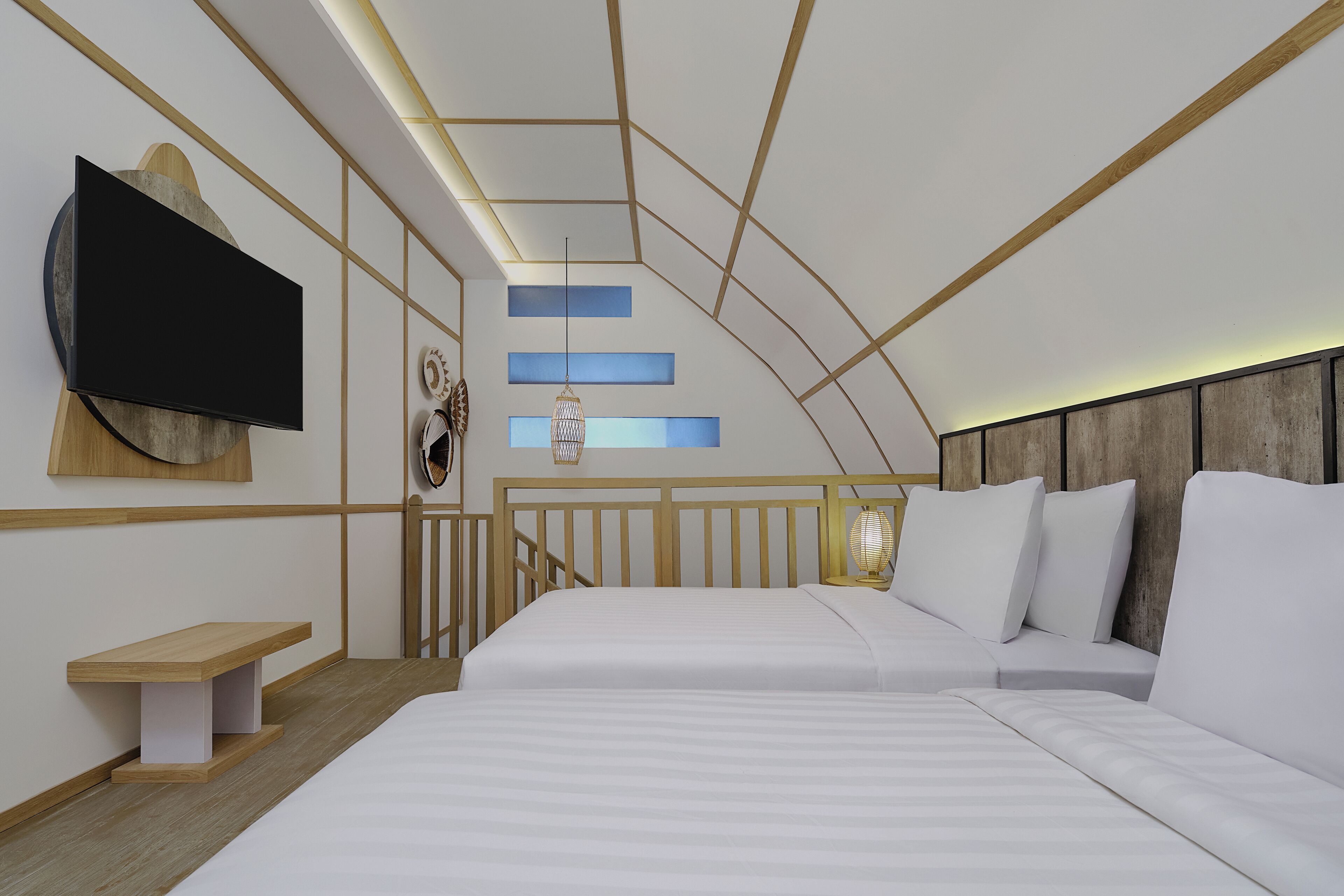 A modern bedroom with a large bed, a TV mounted on the wall, and a wooden bench.