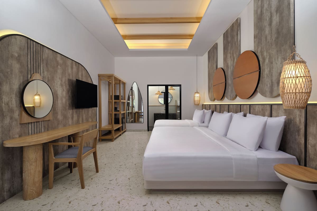 A modern bedroom with a large bed, a desk, and a bookshelf.