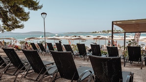 Outdoor seating with a view of the sea and beach umbrellas. - Matilde Beach Resort (Vodice)