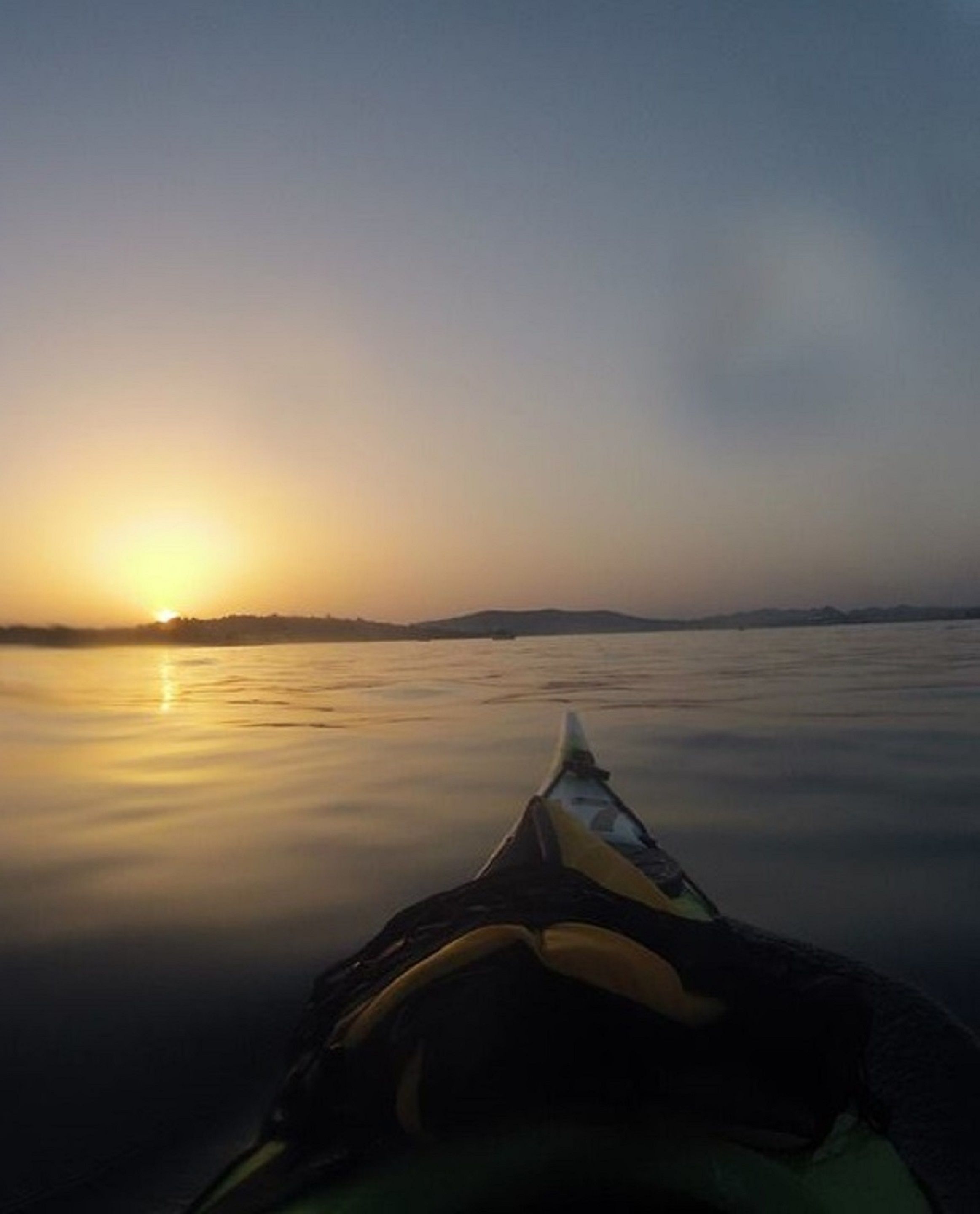 A kayak on calm water during sunset.