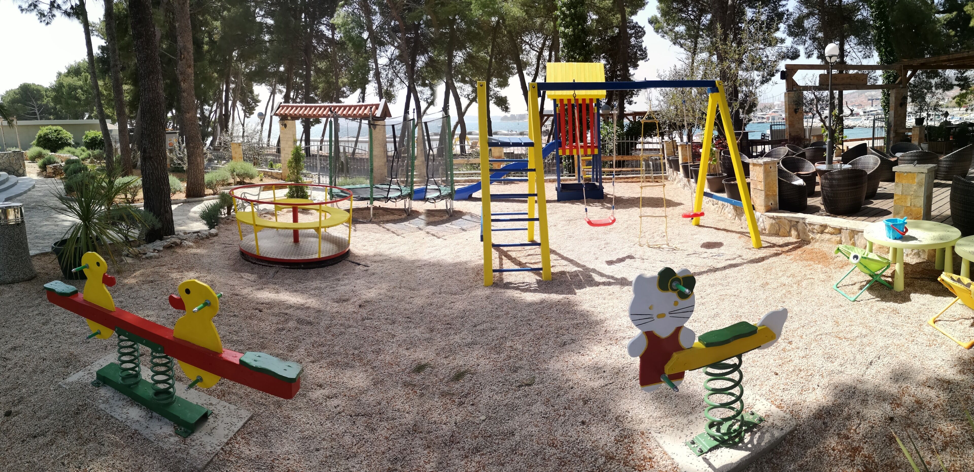 Un parque infantil con columpios, un sube y baja y una estructura para escalar.