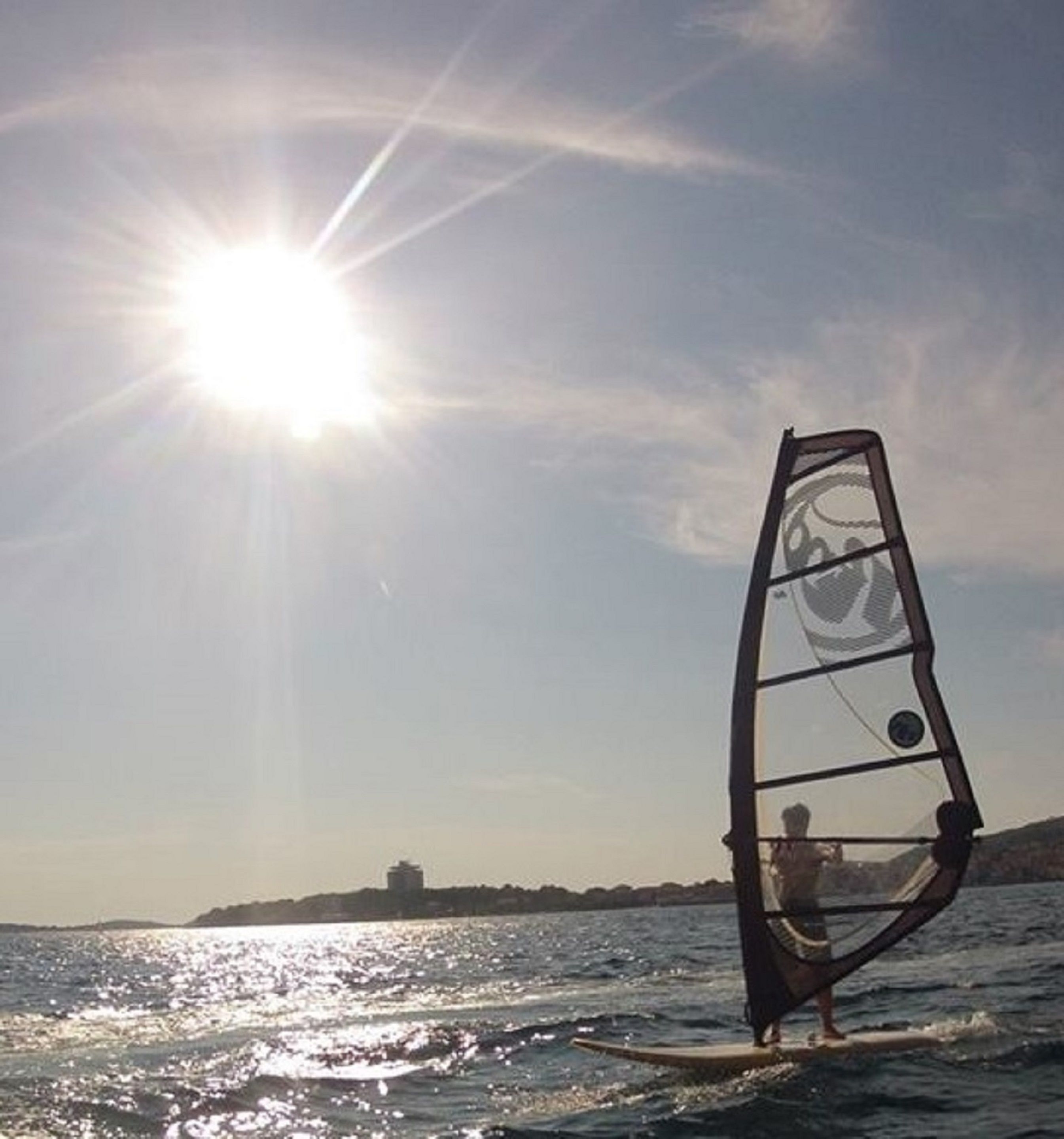 A person windsurfing on a sunny day.