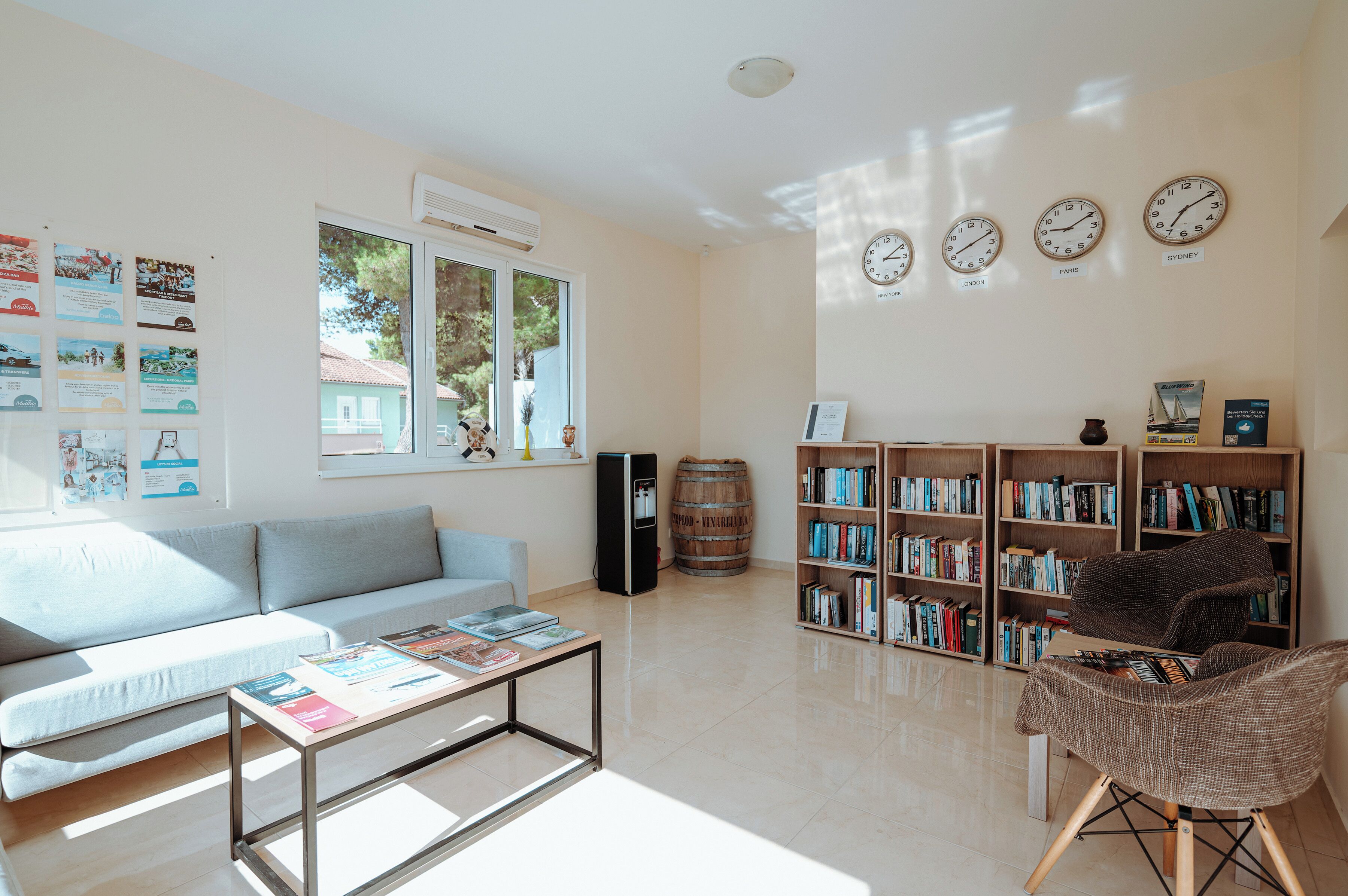 A bright living room with a sofa, coffee table, and bookshelves.