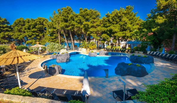 Una piscina al aire libre de temporada, sombrillas