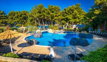 Una piscina al aire libre de temporada, sombrillas