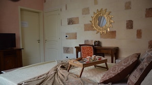A bedroom with a bed, a wooden chair, a small table with cups and a clock, a television, and a mirror on the wall. - A casa di Mich il Salento Lu sule Lu mare Lu ientu (Monteroni di Lecce)