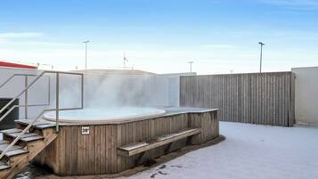 Relax in the hot tub, surrounded by a serene winter landscape.