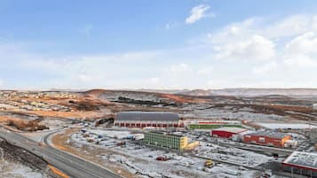 Uma extensa área industrial com vários edifícios, estradas e paisagem coberta de neve.