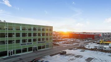 A hotel with a restaurant, multiple floors, and a parking lot with snow.