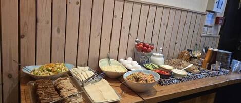 A buffet table with various food items and utensils.