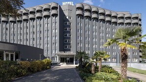 A modern hotel with a central entrance, multiple balconies, and a well-maintained garden. - Hotel Da Vinci (Milan)