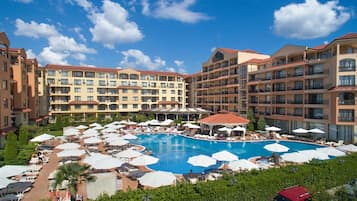 Alberca techada, sombrillas en la alberca y camastros