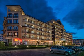 A multi-story hotel with balconies, a medical center, and a parking area.