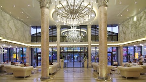 A grand lobby with a large chandelier, ornate columns, and seating areas. - Hotel & SPA Diamant Residence - All Inclusive (Sunny Beach)