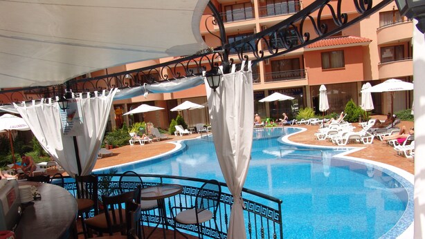 A poolside area with a bar, lounge chairs, and umbrellas. - Apart-hotel Efir (Sunny Beach)