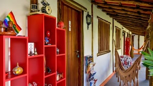 A hallway with red shelves, a hammock, and a door with a sign. - Pousada Estalagem Paraty (Paraty)