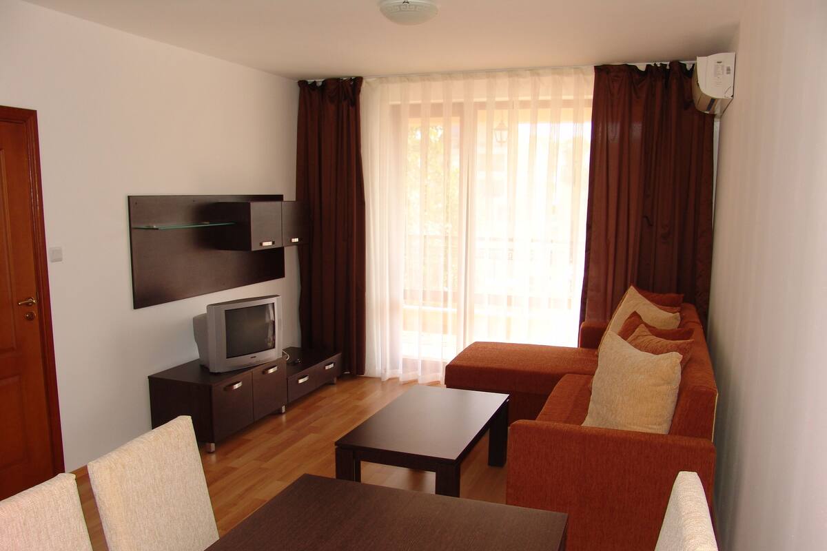 A living room with a TV, sofa, and coffee table.