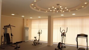 A gym with cardio machines, a treadmill, and a stationary bike. - Apart-hotel Happy (Sunny Beach)