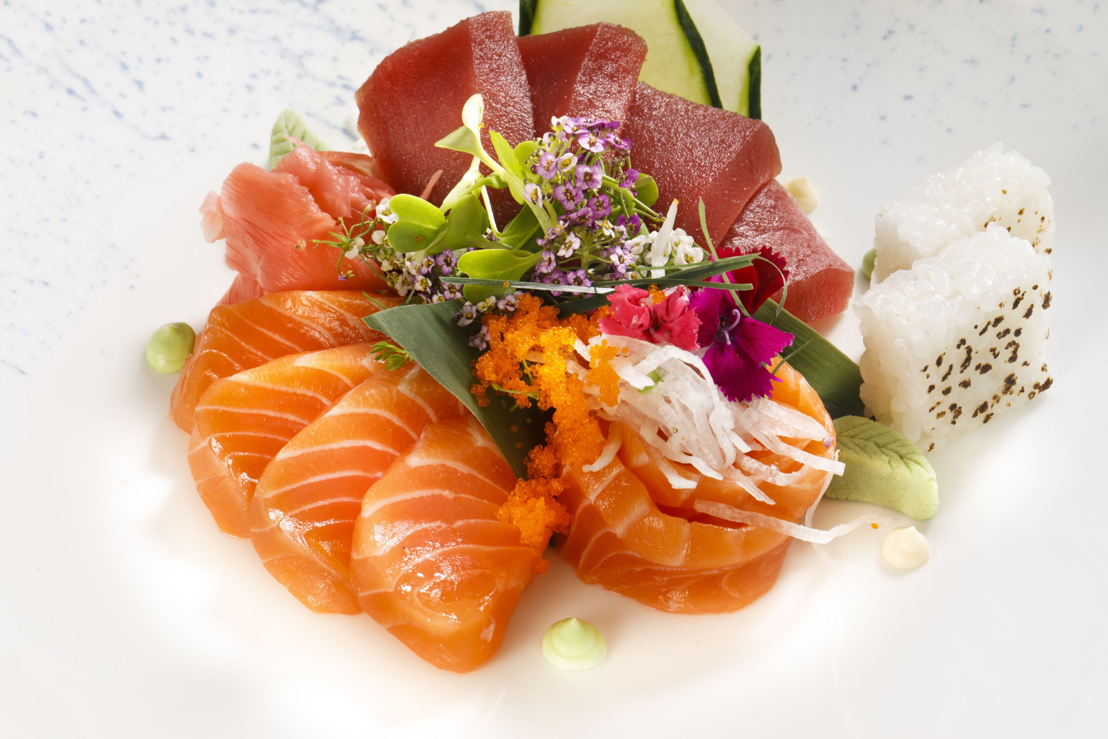 A plate of sushi with various toppings and garnishes.