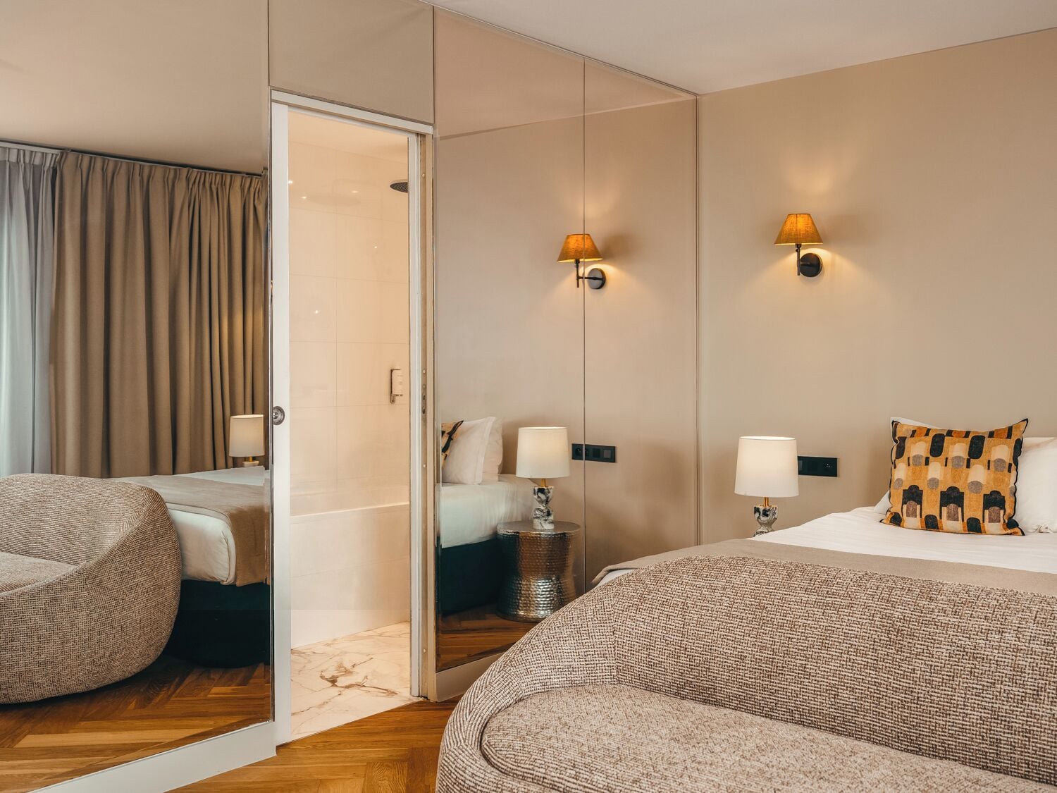 A hotel room with a bed, two bedside tables, a chair, a walk-in closet, and a shower.