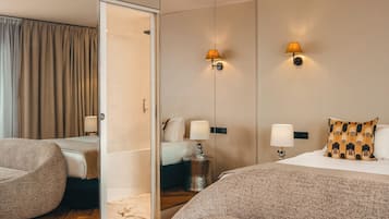 A hotel room with a bed, two bedside tables, a chair, a walk-in closet, and a shower.