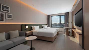 Una habitación de hotel moderna con una cama grande, un sofá, un escritorio y un televisor.