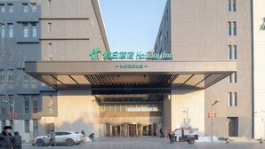 A modern building with a large entrance and signage for a Holiday Inn. - Holiday Inn Beijing Daxing Movie Park by IHG (Daxing)