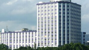 Un hotel de varios pisos con una torre central, que presenta una cuadrícula de ventanas y balcones.