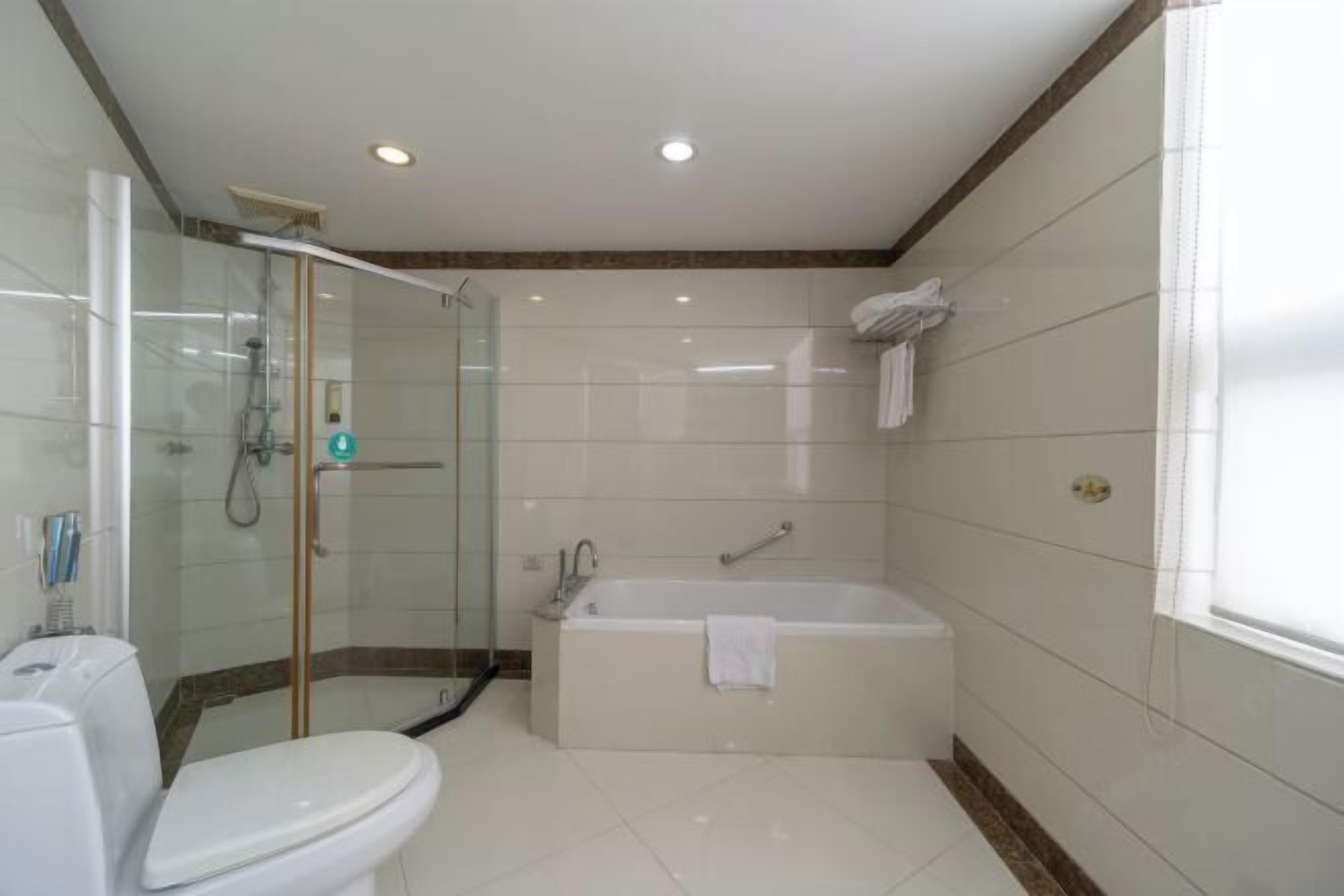 A modern bathroom with a glass-enclosed shower, a standalone bathtub, and a toilet.