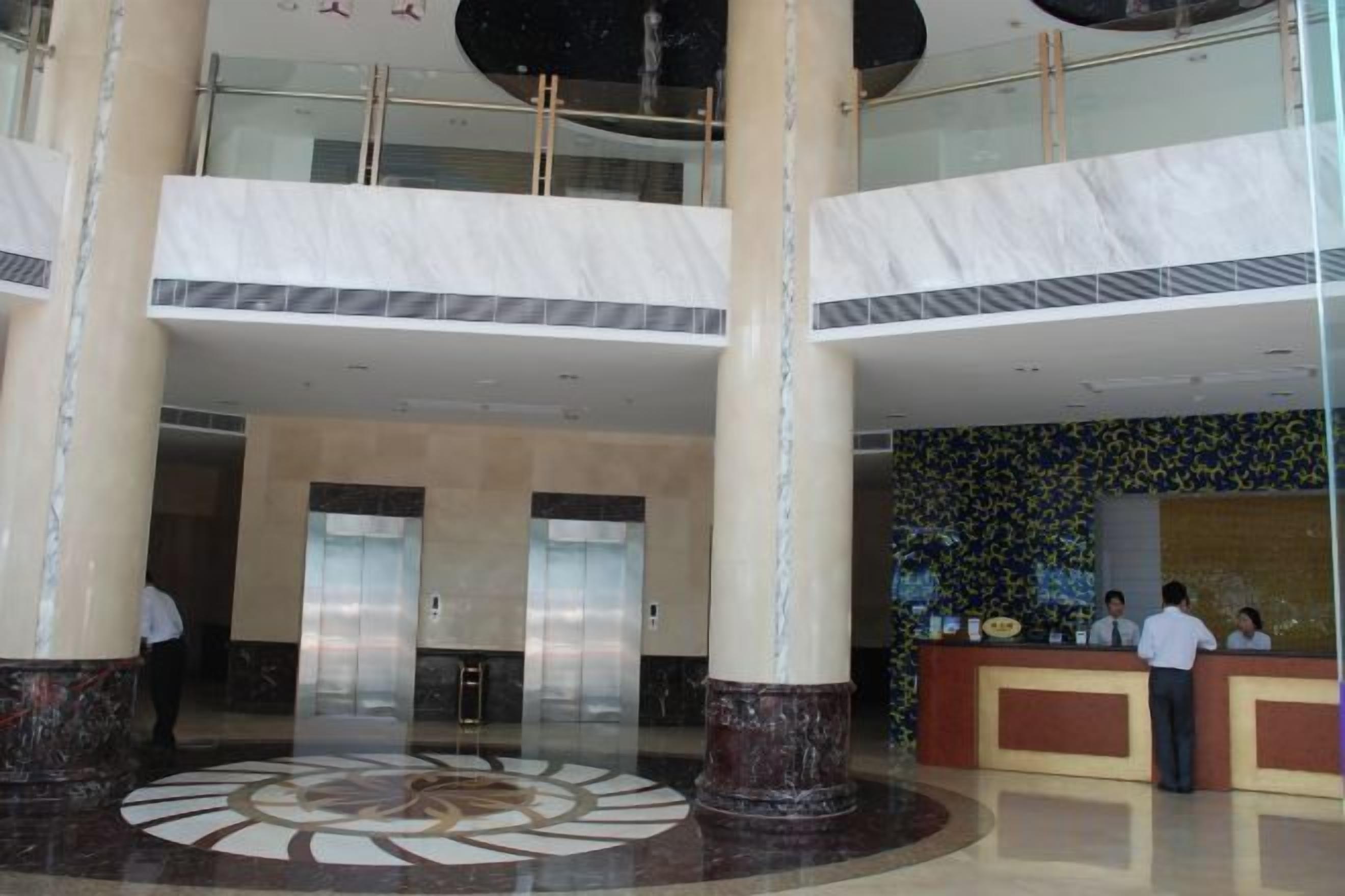 A lobby with a central circular floor design, multiple floors, and a reception desk.