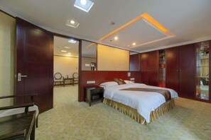 A hotel room with a large bed, a bedside table, a mirror, and a wardrobe. - Kaiping Hotel (Kaiping)