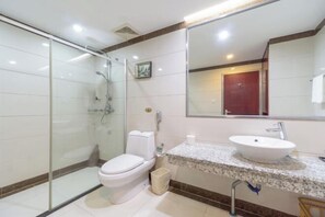 A modern bathroom with a glass-enclosed shower, a toilet, a sink, and a large mirror. - Kaiping Hotel (Kaiping)