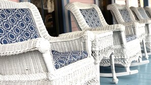 Wicker rocking chairs with patterned cushions on a porch. - The Oak Bluffs Inn (Oak Bluffs)