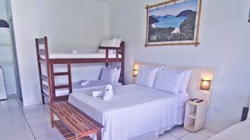 A bedroom with bunk beds, a bedside table, a nightstand, and a painting on the wall.