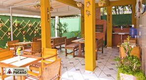 Un restaurant avec des meubles en bois, des murs verts et des plantes en pot.