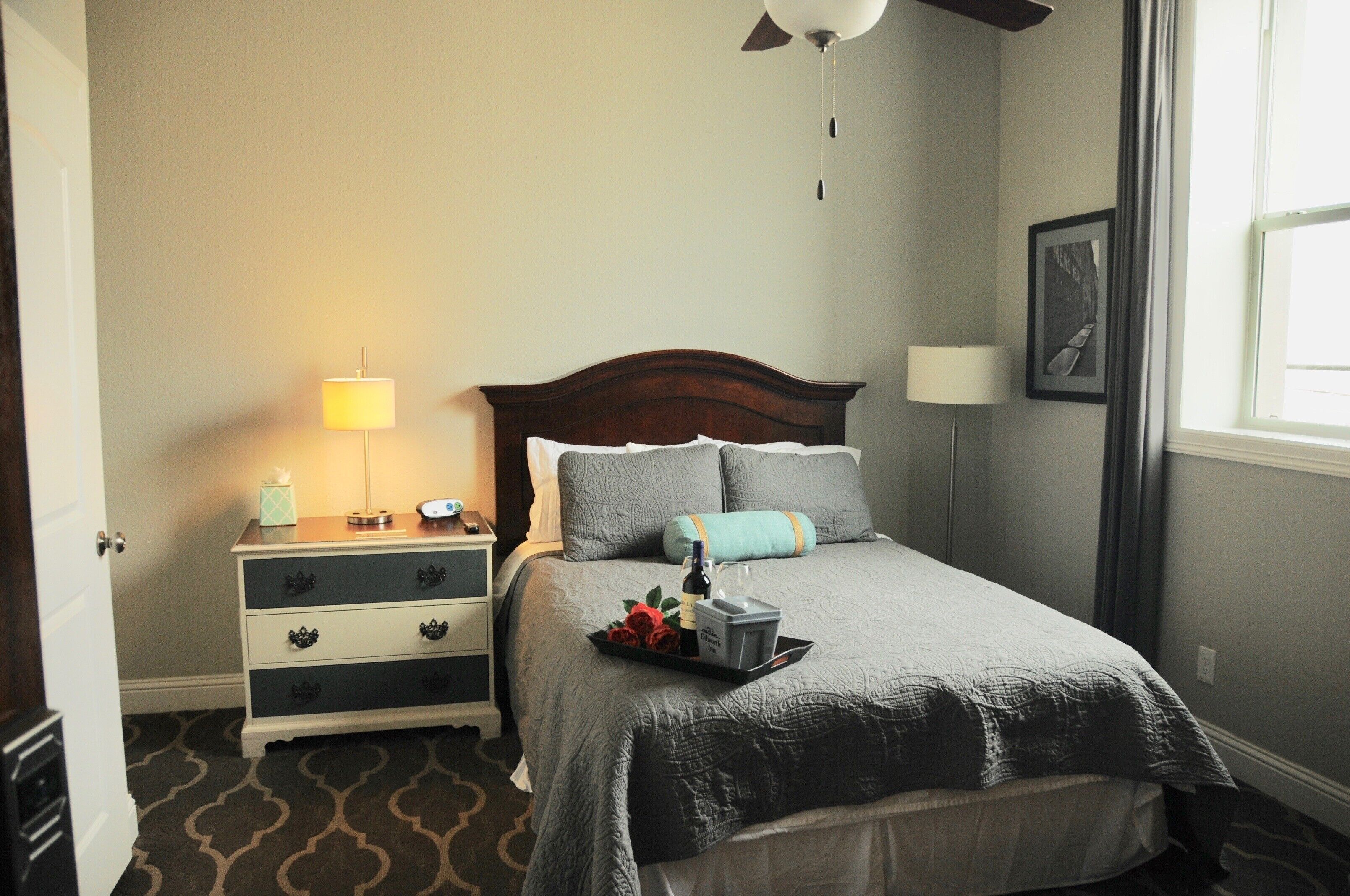 A neatly arranged bedroom with a bed, bedside tables, lamps, and a window.