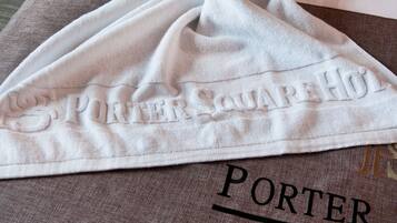 A towel with "PORTER SQUARE HOL" embroidered on it, placed on a brown surface with "PORTER" printed below.