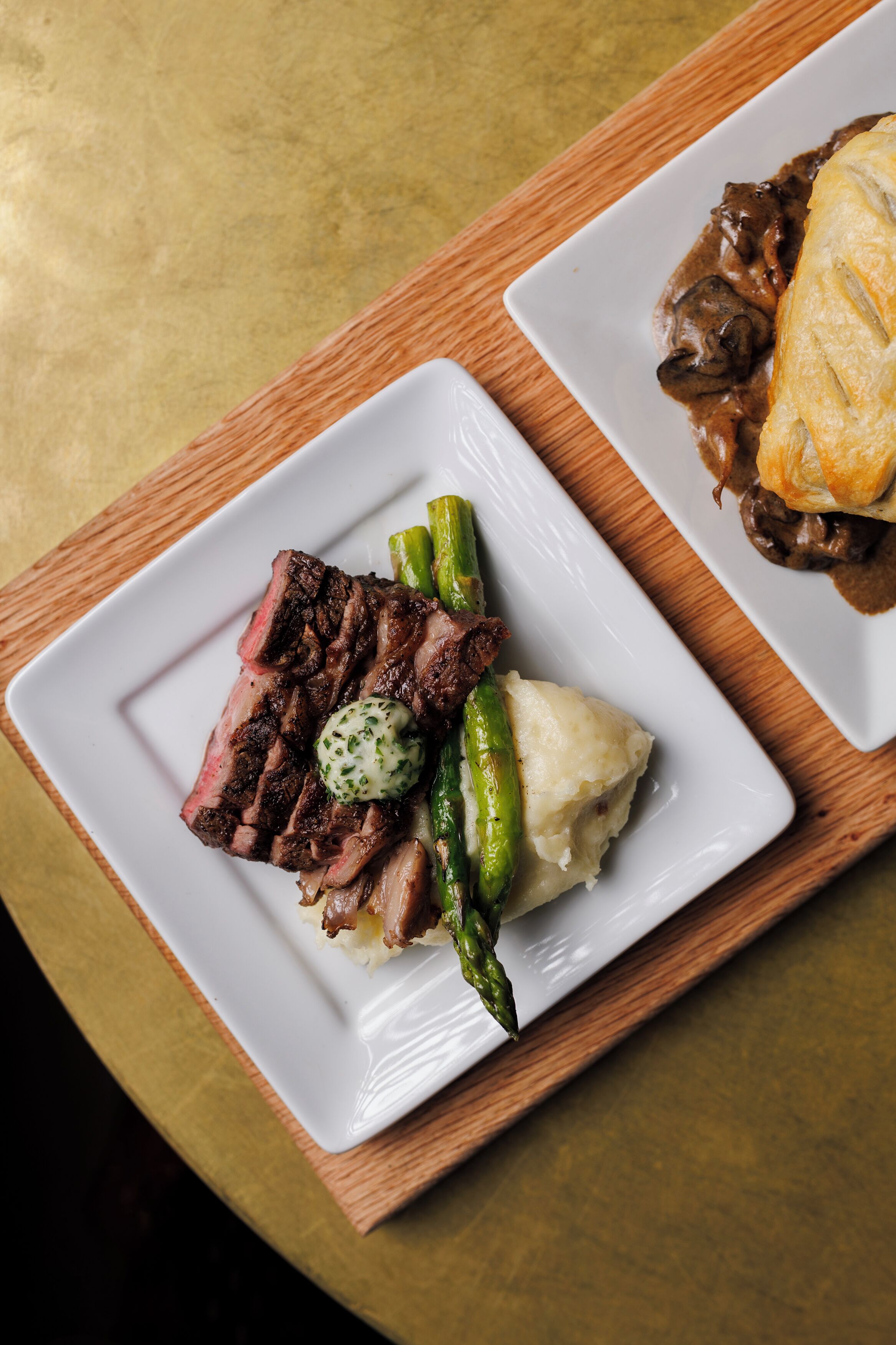 A white plate with steak, asparagus, and mashed potatoes.
