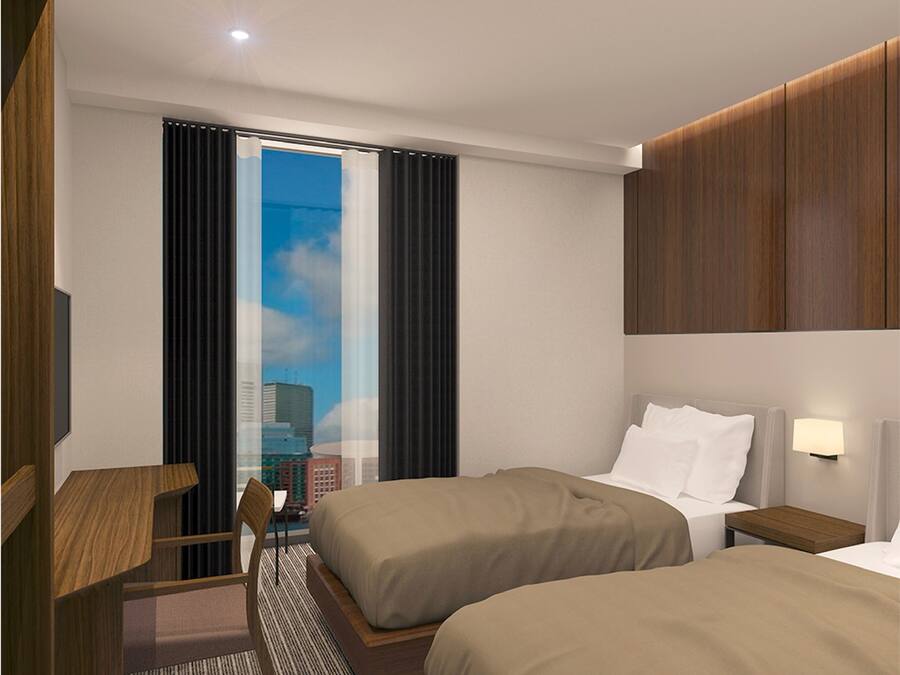 A hotel room with two beds, a desk, a chair, a window with curtains, and a city view.