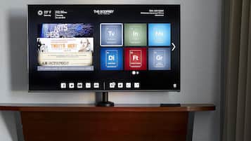 L’écran de télévision d’une chambre d’hôtel affiche une interface numérique proposant diverses options, comme la télévision, l’accès à Internet et les horaires des vols.