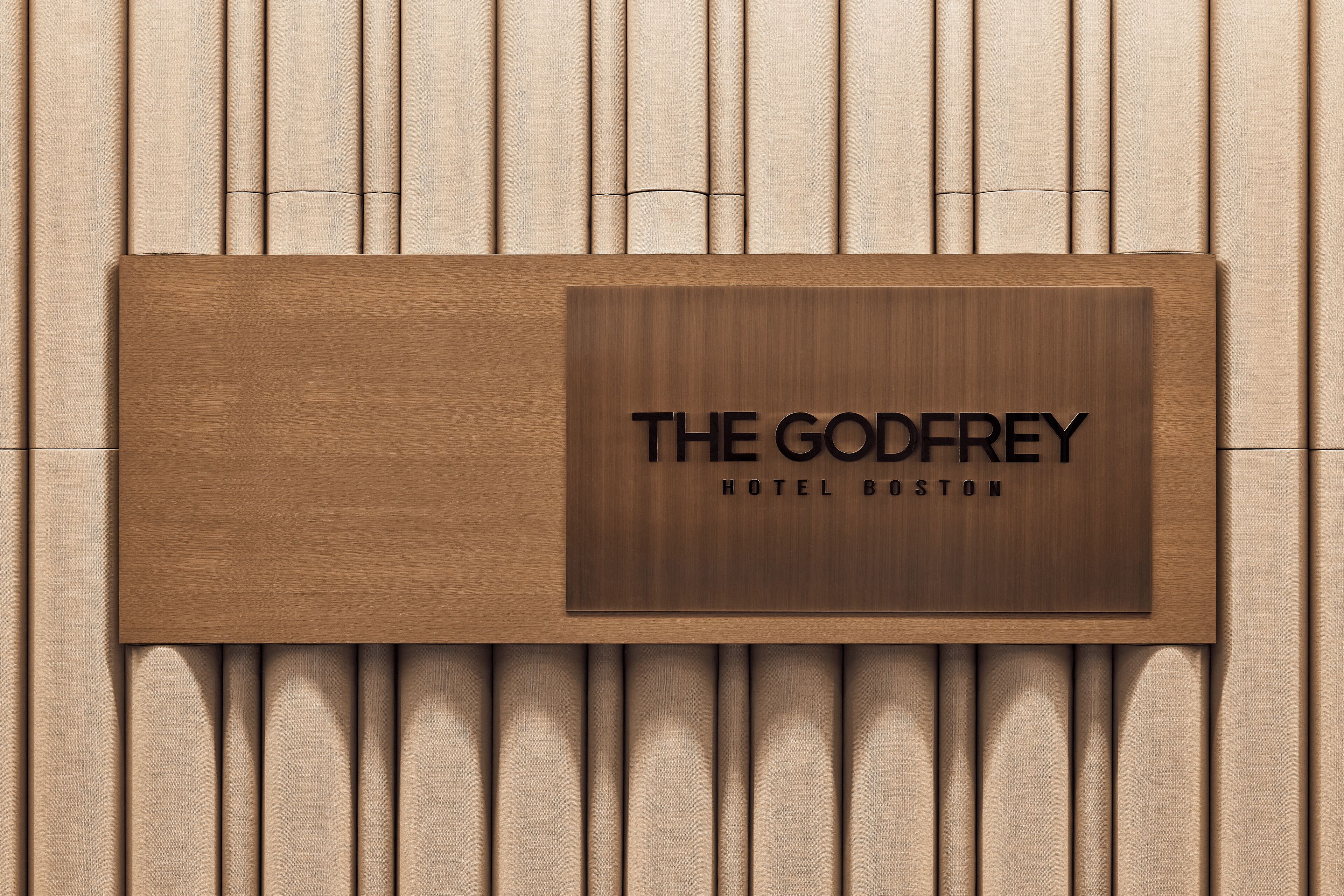 Ein Holzschild mit der Aufschrift 'THE GODFREY HOTEL BOSTON'.