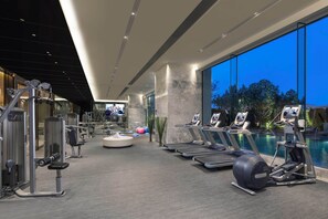 A gym with treadmills, elliptical machines, and free weights.