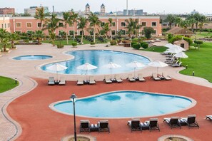 A hotel pool area with multiple pools, sun loungers, and umbrellas. - Radisson Blu Resort, Jizan (Jizan)