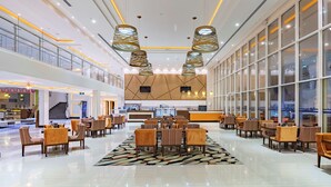 A spacious lobby with a central seating area, large windows, and modern lighting fixtures. - Radisson Blu Resort, Jizan (Jizan)