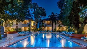 Een buitenzwembad en ligstoelen