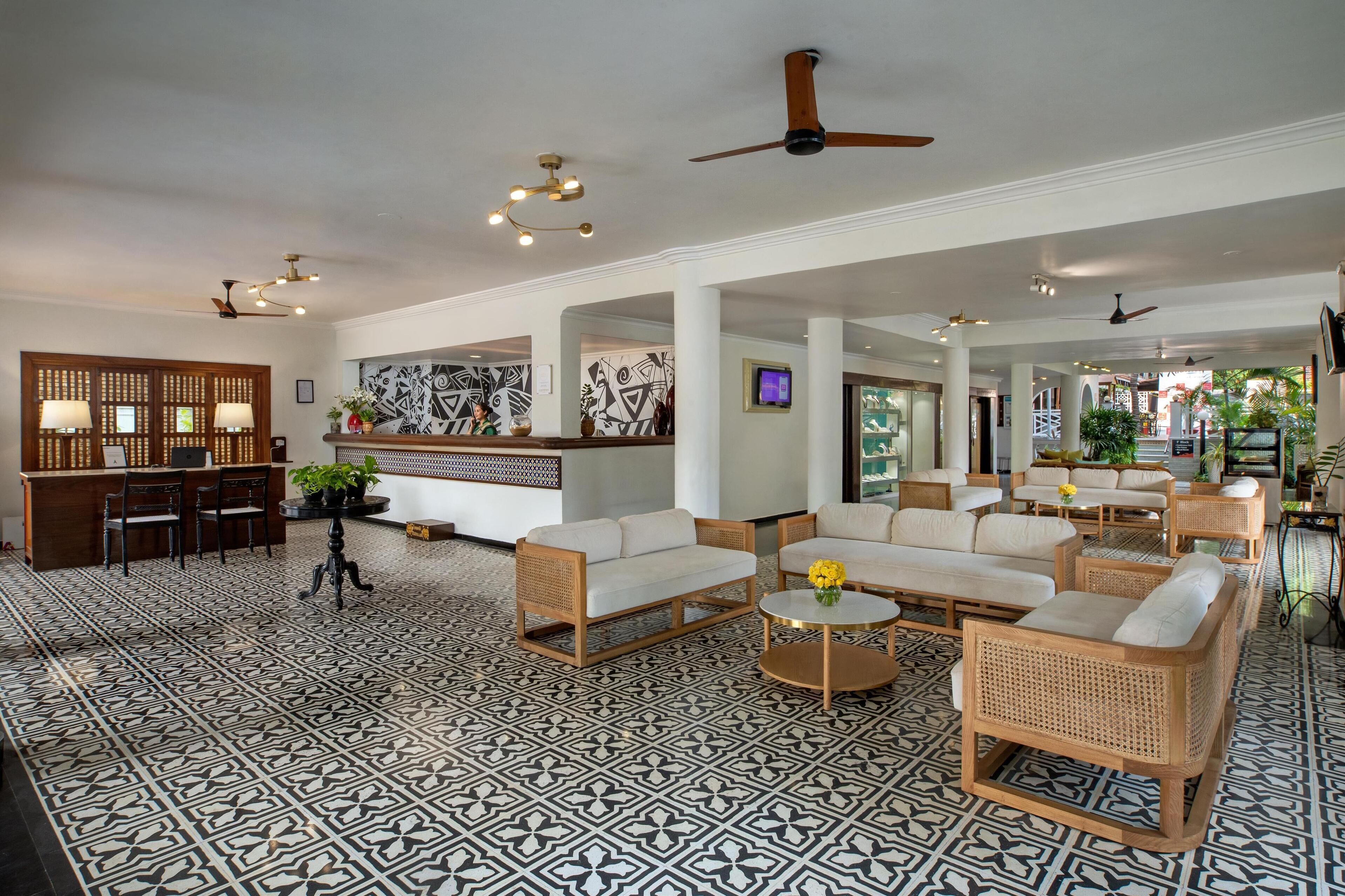 A spacious lobby with a reception desk, multiple seating areas, and a patterned floor.