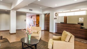 A hotel lobby with a reception desk, seating area, and a decorative floral arrangement. - Sleep Inn & Suites Page at Lake Powell (Page)