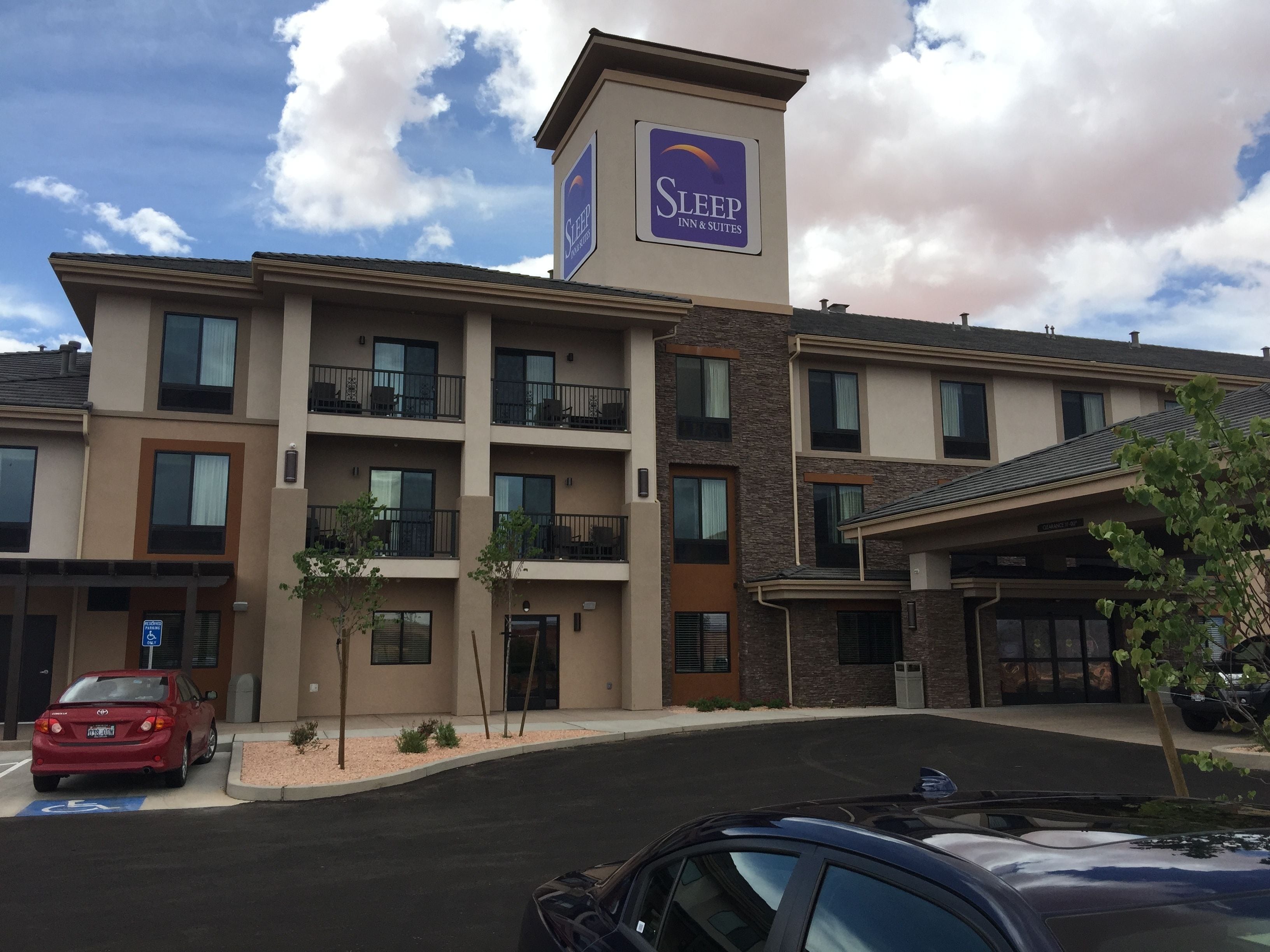 A Sleep Inn & Suites building with multiple floors, balconies, and a parking lot.